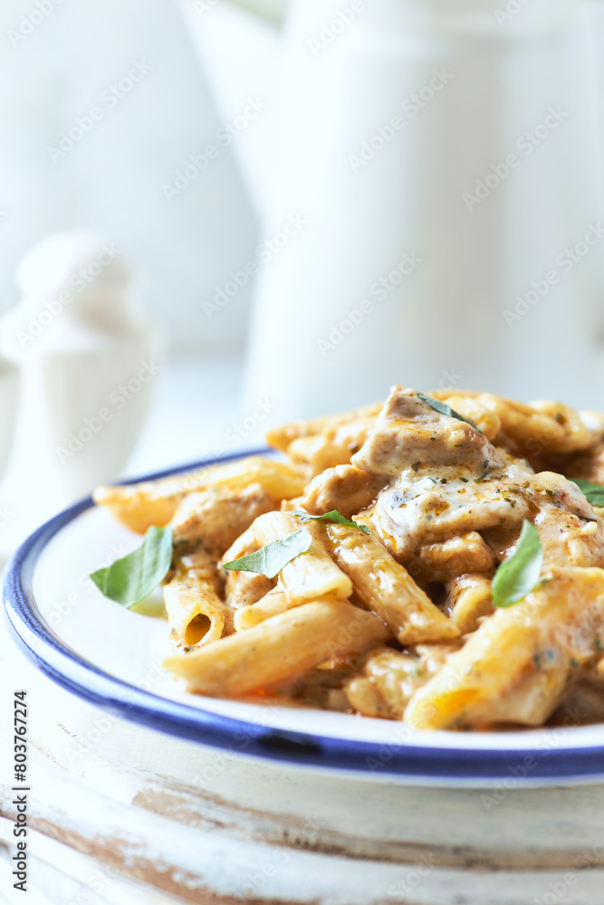 Penne Pasta baked with Meat on bright wooden Background. Close up.