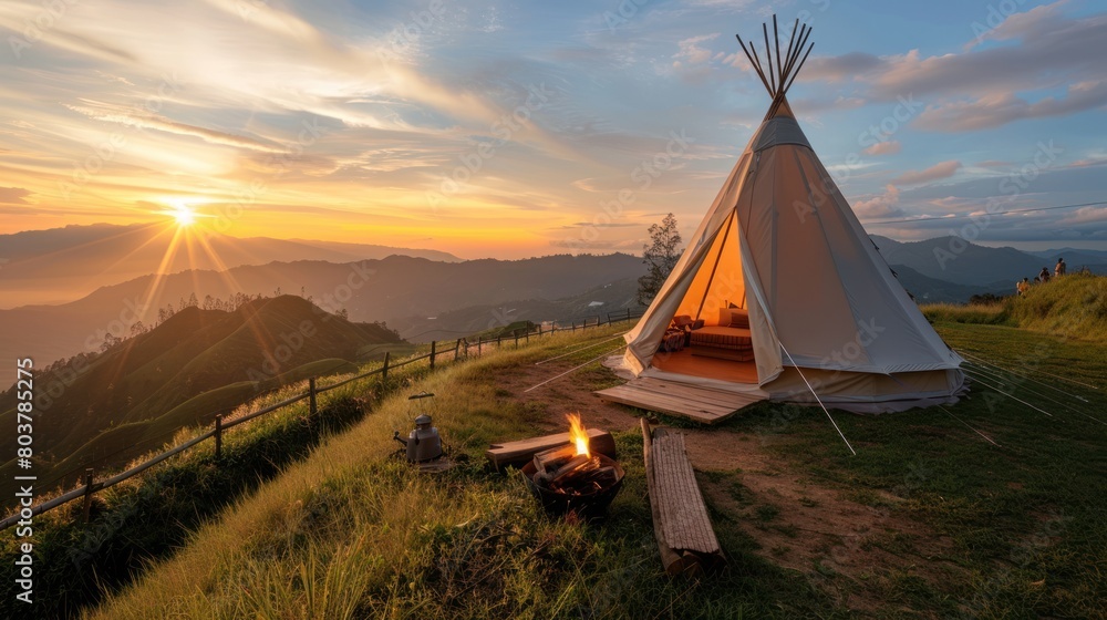 Glamping camping teepee tent on mountain with sunrise