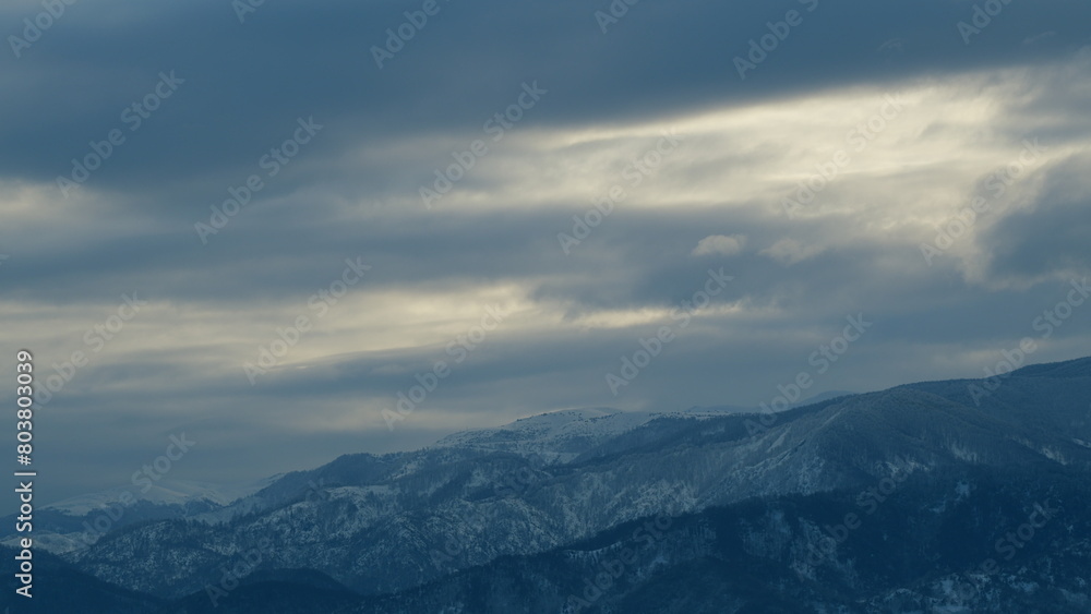Enveloping Misty Clouds Over Snowcapped Mountains. Mountain Peak Covered With Snow On Cloudy Day. Timelapse.