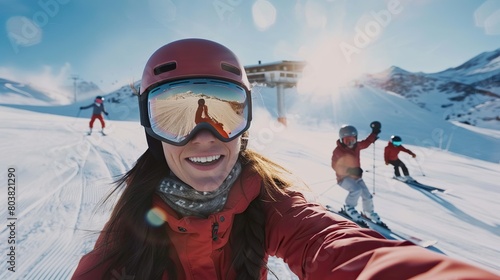 A person skiing down a snowy mountain. The person is wearing a helmet and goggles, and is smiling. There is another person skiing behind her.