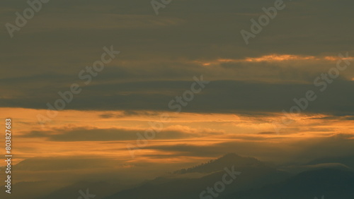 Fototapeta Naklejka Na Ścianę i Meble -  Sunrise With Mountains In Horizon. Majestic Sunset Or Sunrise Cloudscape Amazing Light Of Nature.