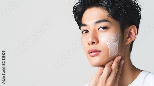 Young Asian man touching his face in the style of Korean style. The closeup shooting depicts skin care and beauty in high detail on a white background with copy space, minimally edited from the origin