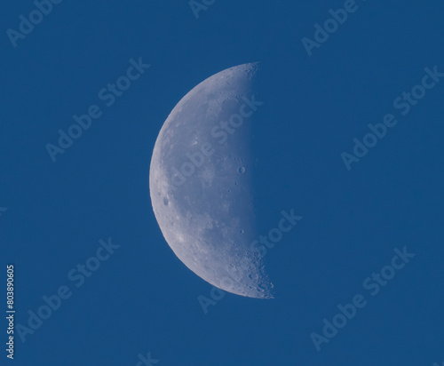 half waxing gibbous moon on dark blue sky © nd700