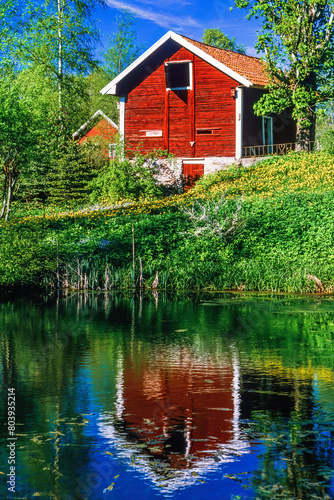 Red cottage with water reflection in the lake