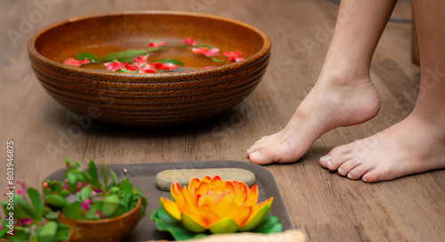 Woman soaks her feet in a bowl with flower petals