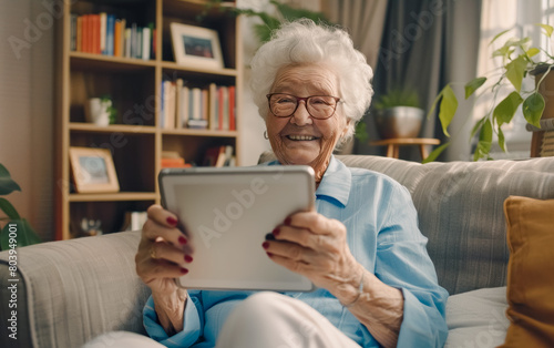 Cinematic photo of an elderly woman sitting on the couch in her living room, smiling and holding up an iPad tablet computer with both hands