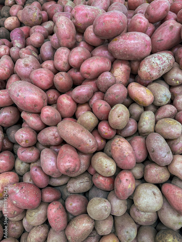 Pink potatoes on a market counter as a background. Texture © schankz