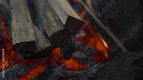 Campfire in the forest. Beautiful wooden campfire on fire between rocks, with particles of fire and ash. Camping, 4k video, close-up