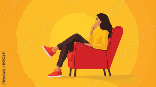 Young woman sitting in armchair on yellow background