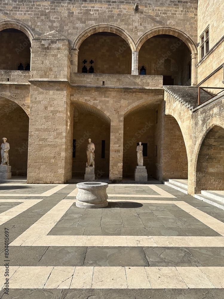 Old Greek marble statues and fountain in the courtyard of the palace of the grand master of the knights of Rhodes in medieval city of Rhodes, Greece