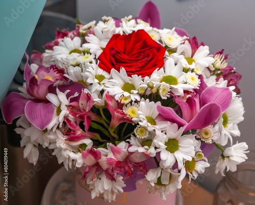 A bouquet of different flowers in close-up on a wall background