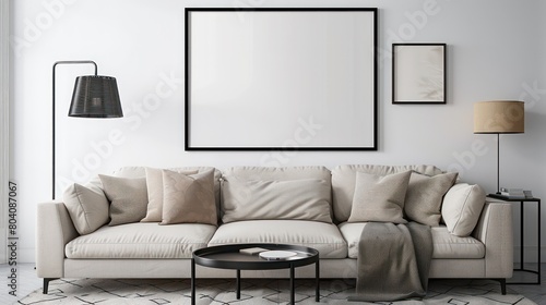 A mockup of an empty poster frame on the wall in a living room  with a sofa and coffee table nearby  on white walls and a carpeted floor  with a lamp stand  a light grey couch with beige cushion.