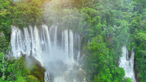 The drone reveals nature s hidden masterpiece - an awe-inspiring waterfall nestled deep within the vibrant tapestry of the tropical jungle  a verdant haven of serenity. Lush woods  Nature s haven. 