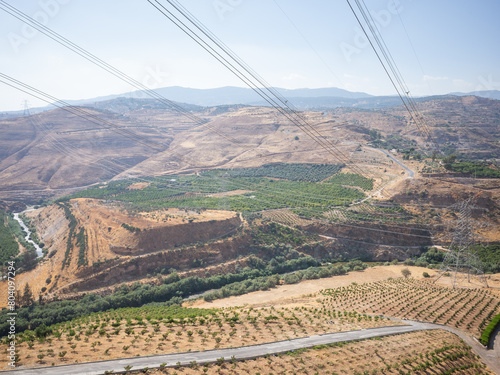 Obraz na plátně scenery of agricultural field in vallery and electric cables seen from higher mo