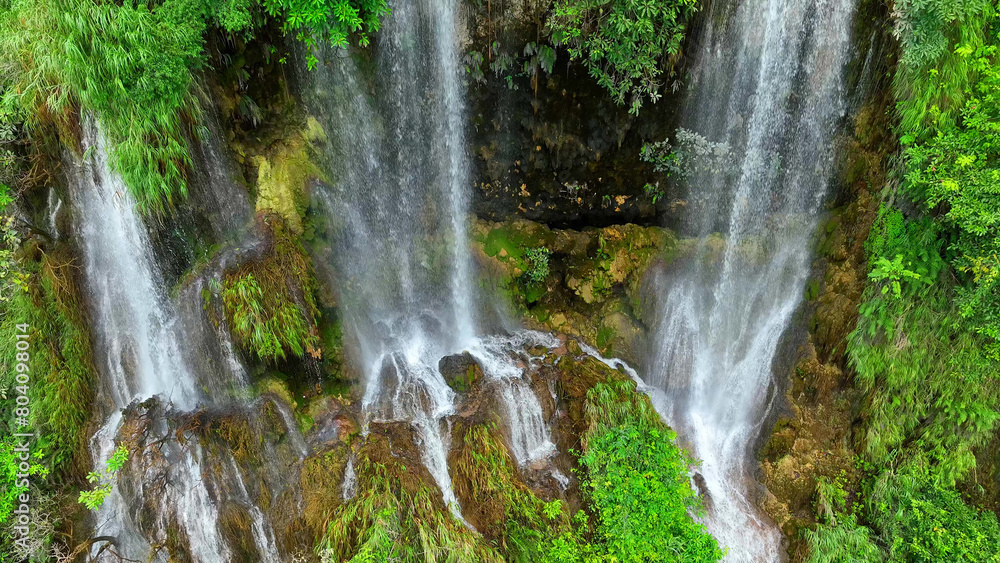 Nature's Hidden Jewel: Unveil the mystique of a triple waterfall nestled deep in a tropical rainforest. Drone footage captures the natural wonder, a serene sanctuary of emerald allure. Thailand.
