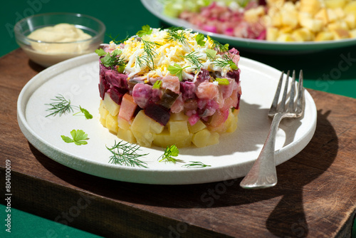 Rosolje -  Estonian beet and herring salad or Rosoli Finland salad with boiled beets, potatoes, apples, onions,  herring or other fish. Ingredients of  Scandinavian cuisine, green background