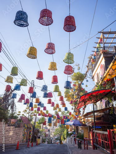 colorful ornaments hanged in the air in front of the cafe of rainbow street in capital amman