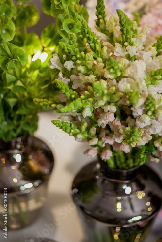 bouquets of flowers are on the table, a tray with a cup and a glass of water