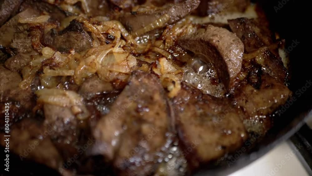 Cooking Fried Pork Liver or Meat in a Hot Frying Pan with Boiling Oil and Onions. Close-up, abstract background, texture. Juicy pieces of liver stewing in a frying pan. Selective focus. Steam. Cooking Fried Pork Liver or Meat in a Hot Frying Pan with Boiling Oil and Onions. Close-up, abstract background, texture. Juicy pieces of liver stewing in a frying pan. Selective focus. Steam.