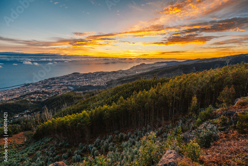 beautiful sunset over the city of Funchal on Madeira from the location Miradouro do Pico Alto. Mountains landscape