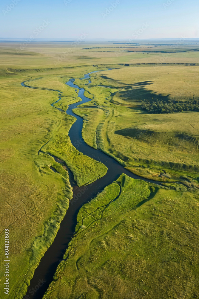 Aerial view of an endless grassland with a distant river Aerial view of an endless grassland with a distant river