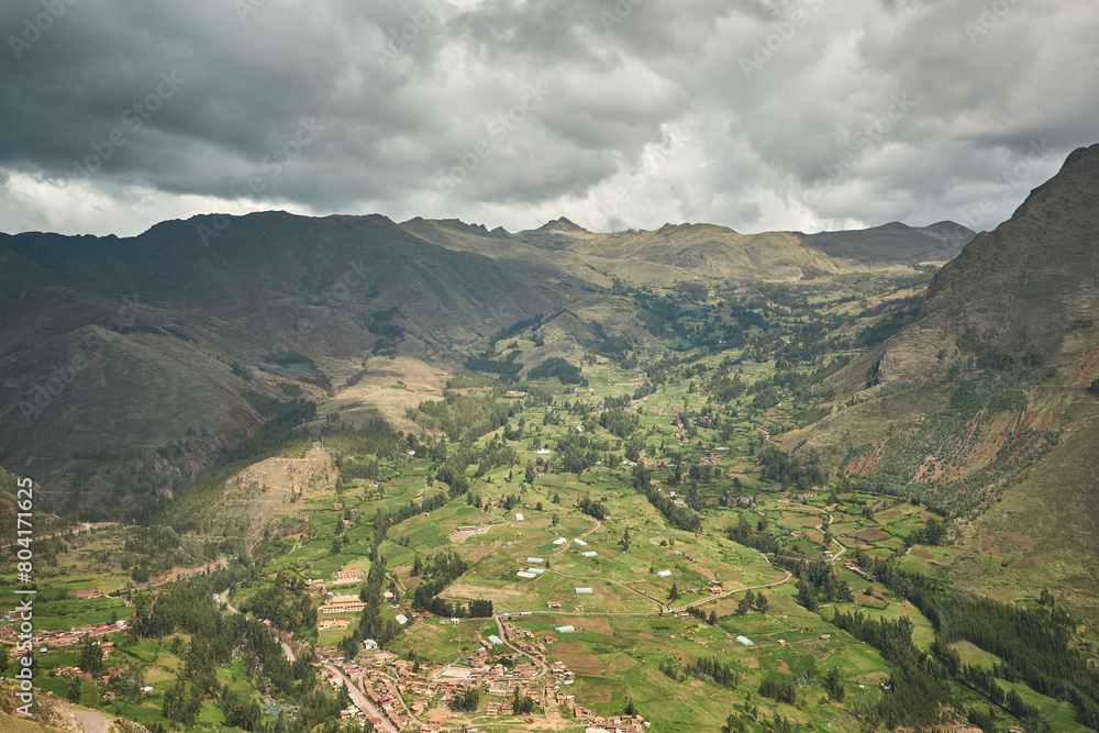 Vast green valley with mountain ranges and small town in Peru
