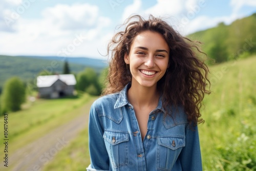 Portrait of a cheerful woman in her 20s sporting a versatile denim shirt isolated in quiet countryside landscape