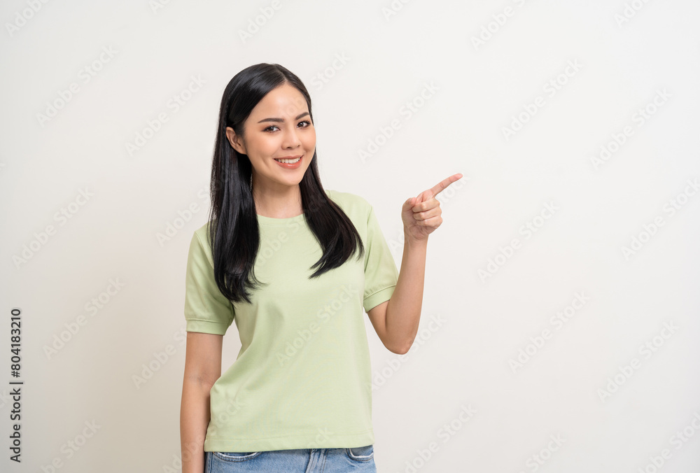 Beautiful smiling happy young asian woman in green shirt. Charming female lady pointing finger to copy space on isolated white background. Asian woman cute Pretty people looking blank space. Beautiful smiling happy young asian woman in green shirt. Charming female lady pointing finger to copy space on isolated white background. Asian woman cute Pretty people looking blank space.