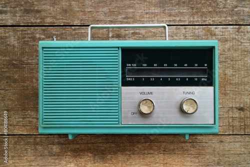 Fotografie old green transistor radio circa 1960s with wooden background