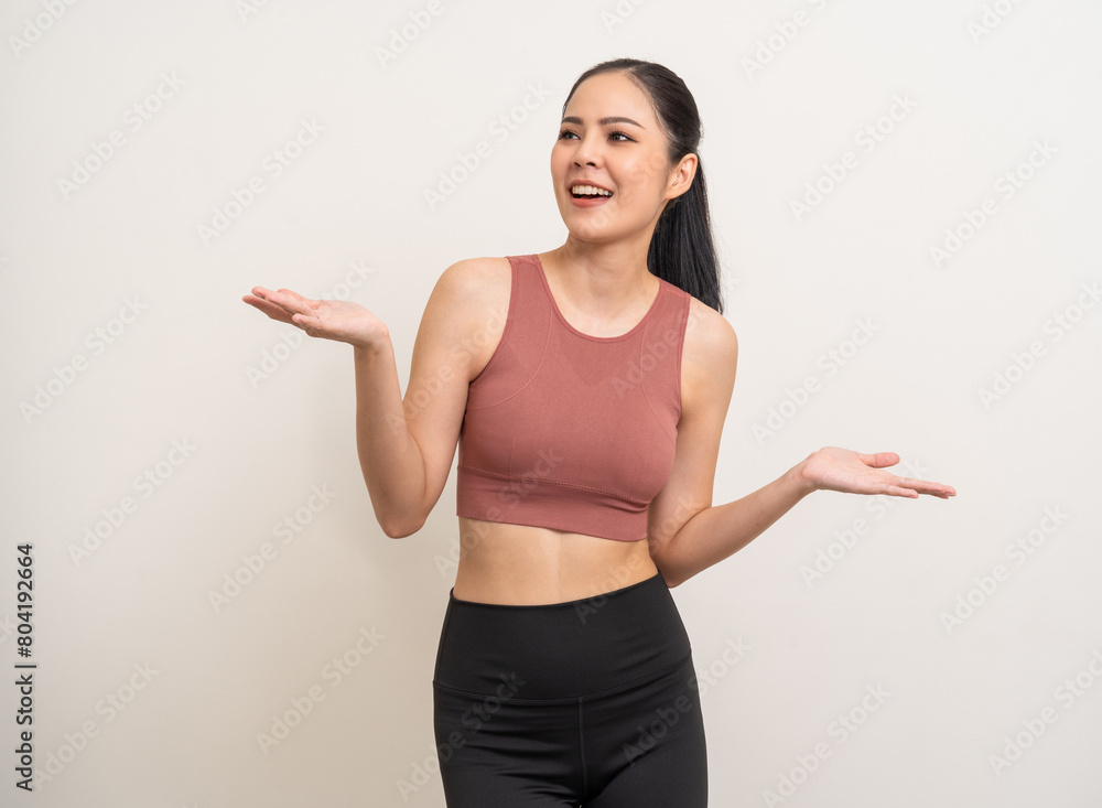 Young beautiful smiling asian woman with sportswear hand palm up with copy space on isolated. Happy healthy slim fit and firm latin attractive sporty woman standing pose exercise workout in studio. Young beautiful smiling asian woman with sportswear hand palm up with copy space on isolated. Happy healthy slim fit and firm latin attractive sporty woman standing pose exercise workout in studio.