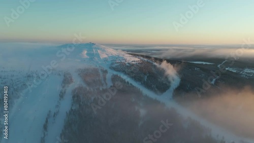 Aerial view rising toward the top of Levitunturi slopes, winter sunrise in Lapland photo
