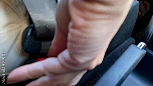 Hand Unbuckles Seat Belt, Slow Motion Close-Up photo