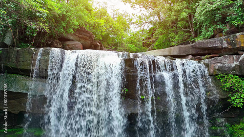 Drone captures breathtaking tropical waterfall cascading from towering cliff in lush forest. Thung Na Muang Waterfall, Pha Taem National Park, Ubon Ratchathani Province, Thailand. Travel concept.
 photo