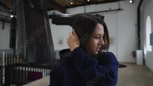 Frustrated female brunette fix hair at art gallery David Cerny, Prague photo