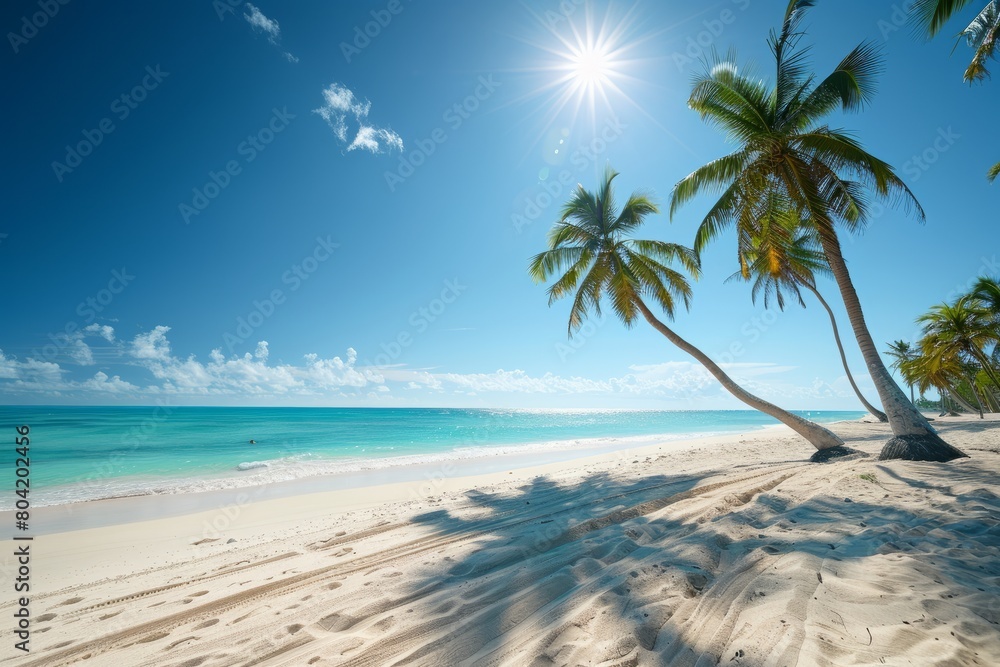 A tropical beach with palm trees swaying in the breeze and turquoise waters of the ocean in the background