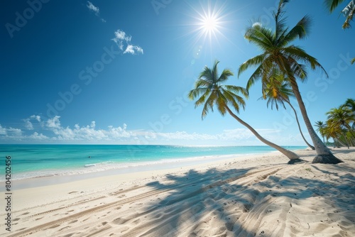 A tropical beach with palm trees swaying in the breeze and turquoise waters of the ocean in the background