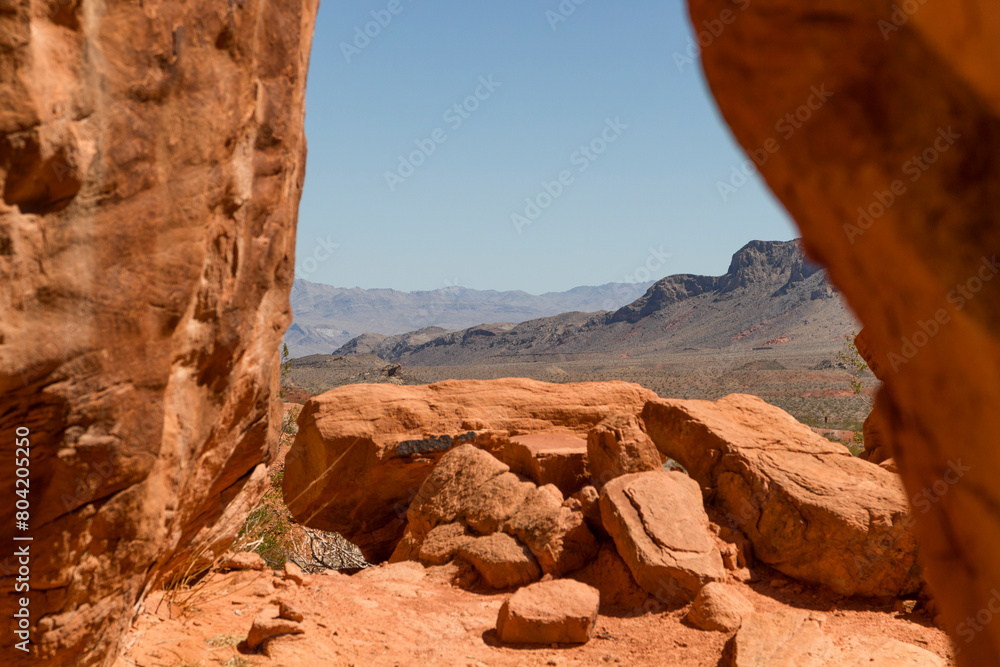 looking through the iconic orange sandstone formations to the mountain range of the valley of fire state park, Nevada