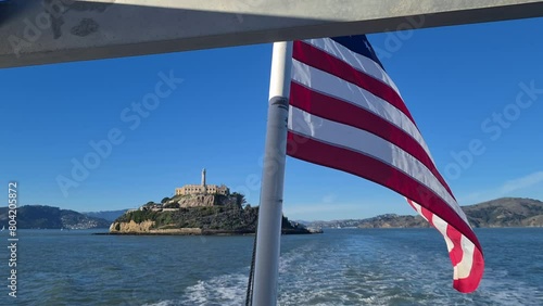 American Flag Waving on Ferry Boat With Alcatraz Island and Prison Buildings in Background, San Francisco CA USA