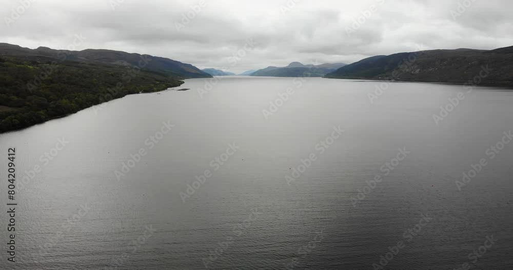 Aerial View Over Calm Waters Of Loch Ness With Clouds Overhead. Pull Back, Tilt Up Shot Aerial View Over Calm Waters Of Loch Ness With Clouds Overhead. Pull Back, Tilt Up Shot