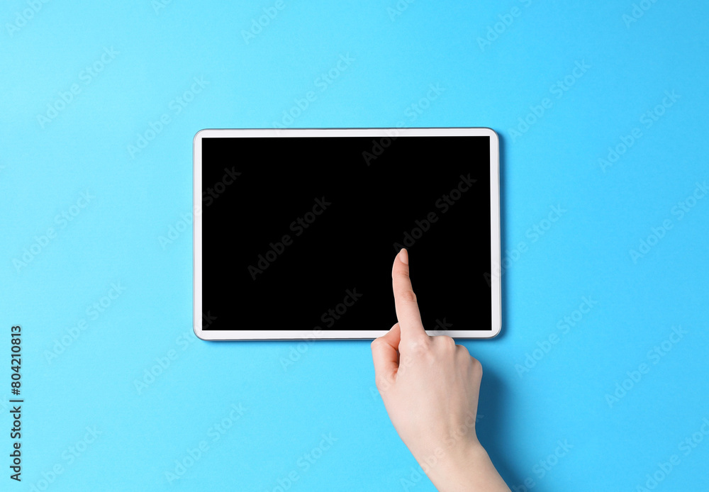 Online store. Woman using tablet on light blue background, top view Online store. Woman using tablet on light blue background, top view