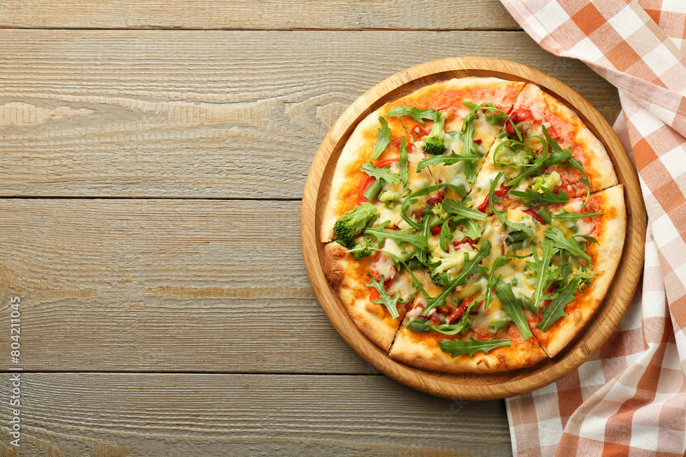 Board with delicious vegetarian pizza on wooden table, top view. Space for text Board with delicious vegetarian pizza on wooden table, top view. Space for text