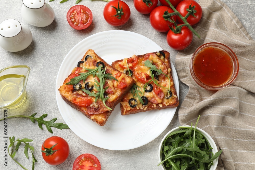 Tasty pizza toast and ingredients on grey table, flat lay Tasty pizza toast and ingredients on grey table, flat lay