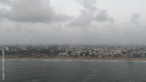 A sweeping drone footage showcasing the urban landscape of Chennai, with clouds casting dramatic shadows over Beach. photo