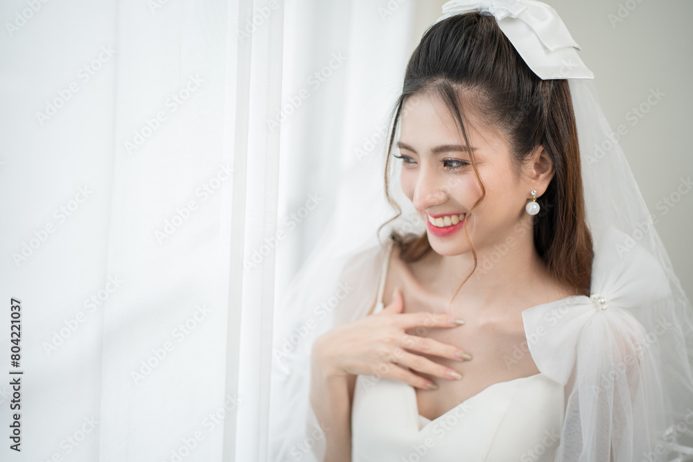 Beautiful asian bride with fashion wedding hairstyle and makeup. Portrait of young gorgeous bride wedding studio shot in white room. Beautiful asian bride with fashion wedding hairstyle and makeup. Portrait of young gorgeous bride wedding studio shot in white room.