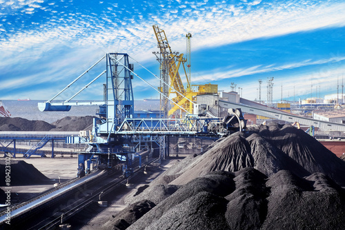 Cuadro en lienzo Coal harbor at maritime dry bulk cargo terminal, bucket wheel stacker reclaimer reloads coal onto an automatic conveyor belt