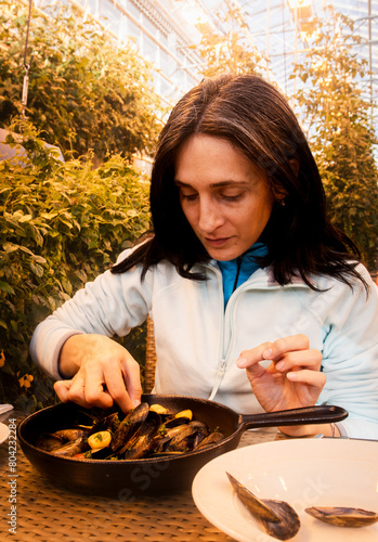 South Iceland-2nd march, 2023: caucasian tourist woman visitor eat portion of mussels in Fridheimar - visitors friendly tomato farm and restaurant in Iceland