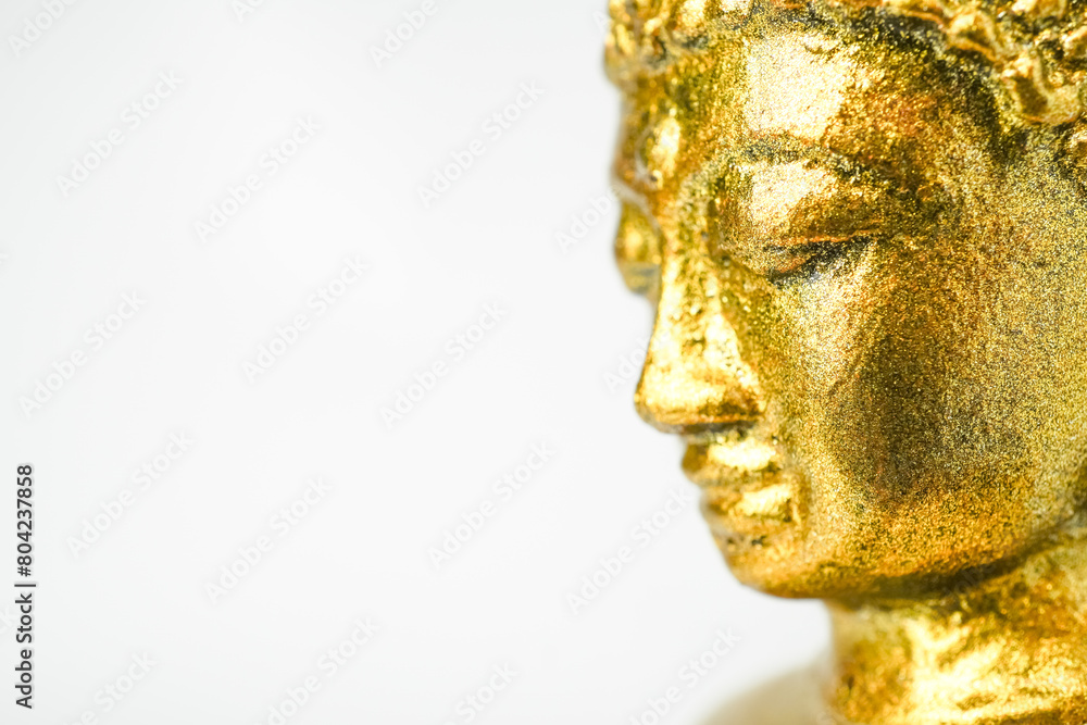 A golden statue of a Buddhist figure meditating facing the side isolated on white background. Bodhisattva Face. Concept for Vesak Day and Enlightenment Day A golden statue of a Buddhist figure meditating facing the side isolated on white background. Bodhisattva Face. Concept for Vesak Day and Enlightenment Day