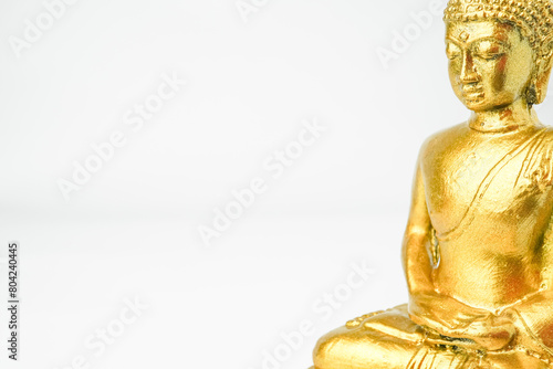 A golden statue of a Buddhist figure meditating facing the side isolated on white background. Bodhisattva Face. Concept for Vesak Day and Enlightenment Day