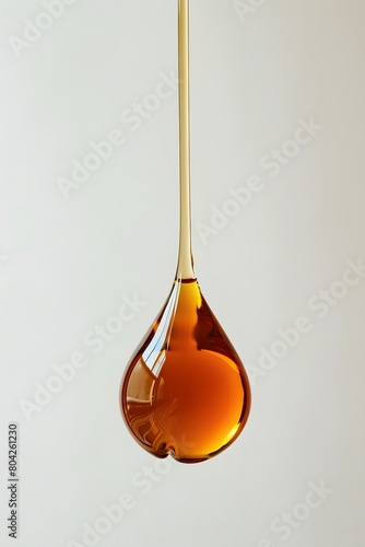 Flowing sophisticated drop of golden liquid on a white isolated background.