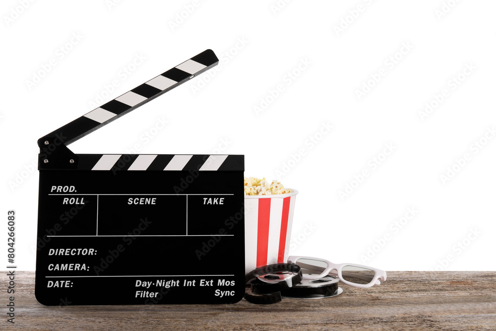 Obraz premium Movie clapper, bucket of tasty popcorn, glasses and film reel on wooden table against white background, space for text